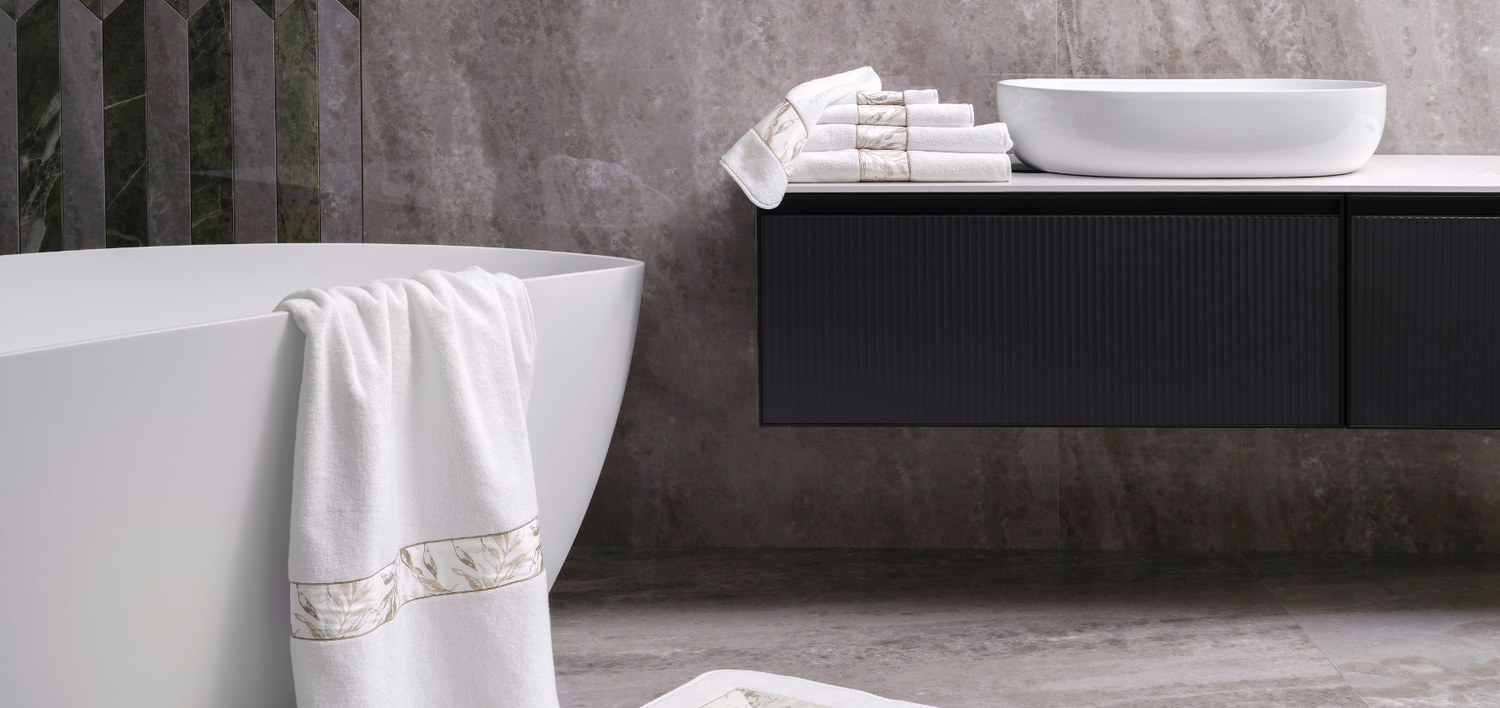 Bathroom setting with a white bathtub, towel, and sink.